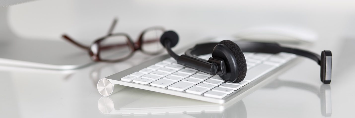 headset, glasses and keyboard at employee help desk