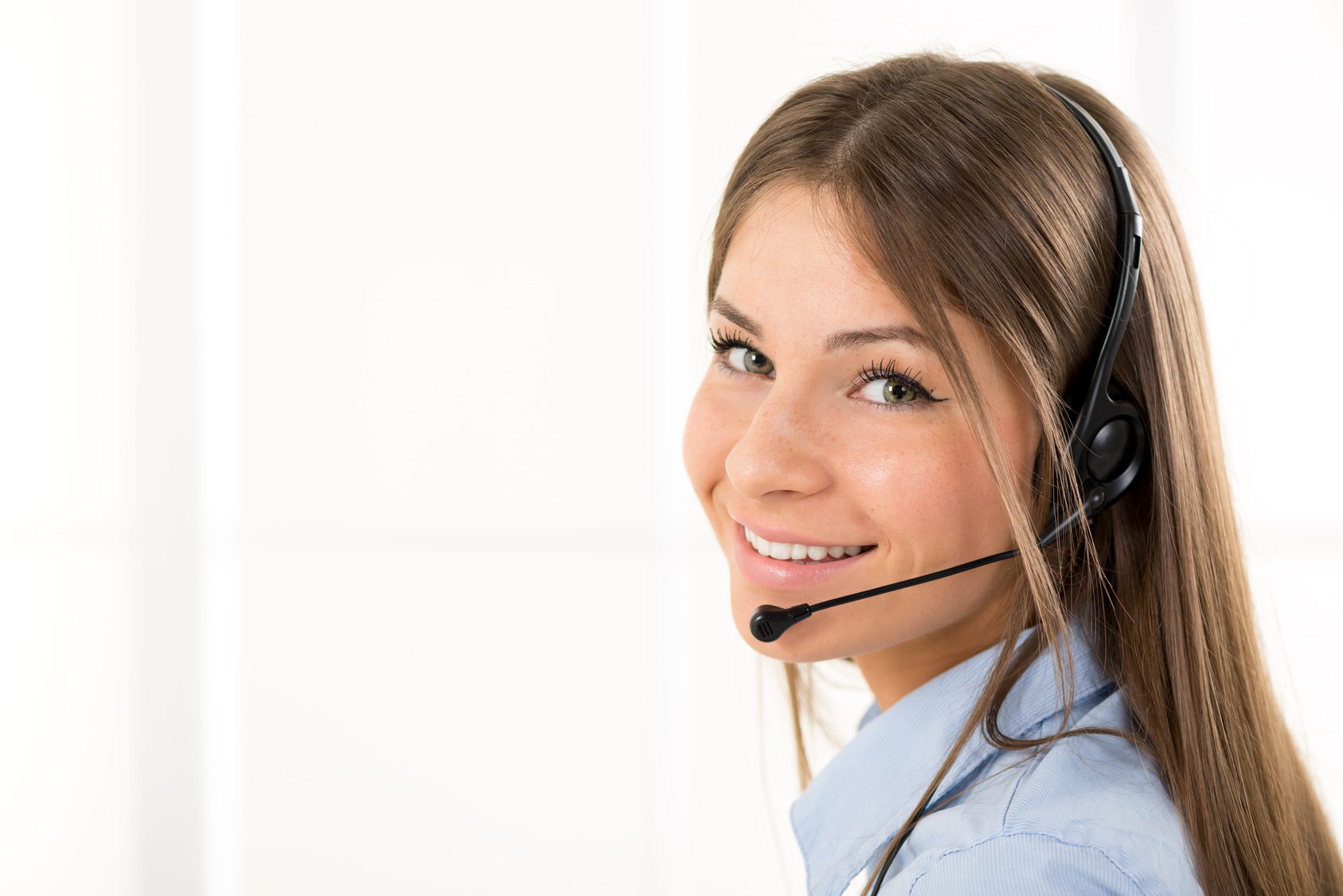 Young beautiful woman, call operator with headset smiling looking at the camera.
