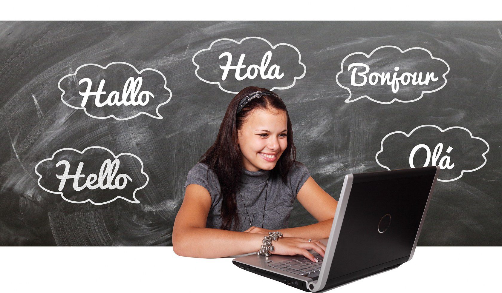Image of a young woman at a laptop with multiple languages representing the importance of going beyond a bilingual answering service