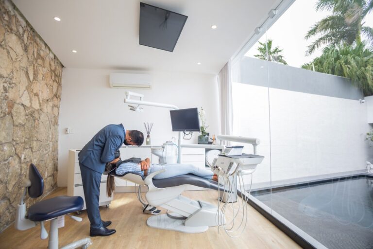 image of a dentist helping a patient showing how an answering service for dentists can help dentists focus on their patients