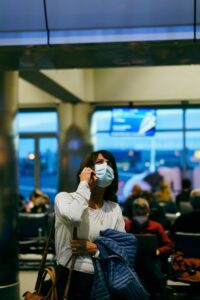 image of a woman on the phone at the airport contacting a taxi call answering service