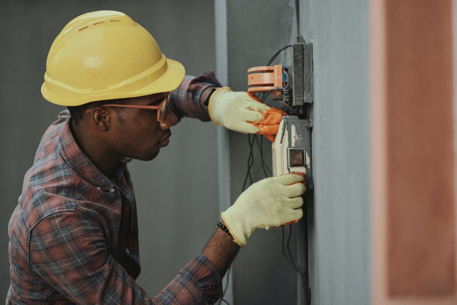 image of a man working on electrical wiring illustrating the importance of hiring an answering service for electricians